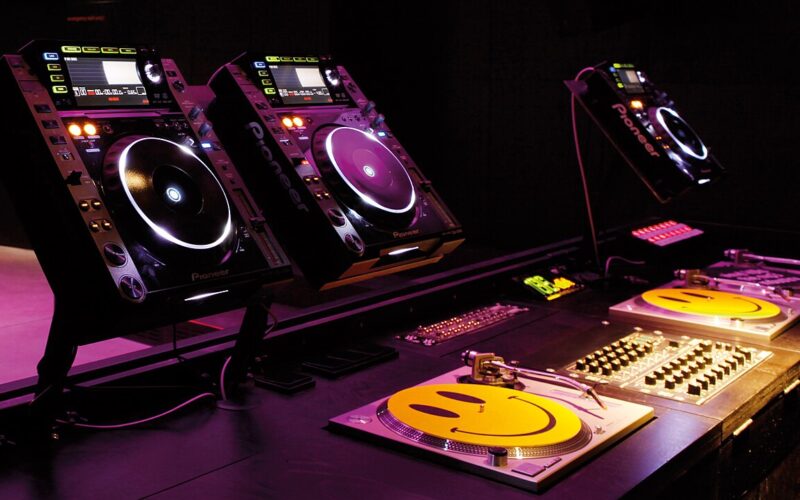 Trois lecteurs CDJ et deux platines dans une cabine de DJ